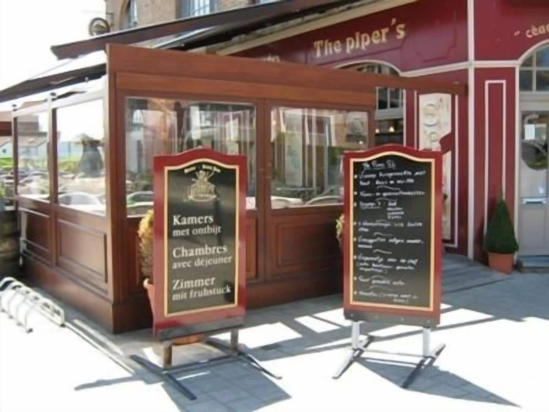 Une structure en bois sur laquelle on peut lire l’inscription « The Piper’s » et une autre affiche présentant une liste d’articles.