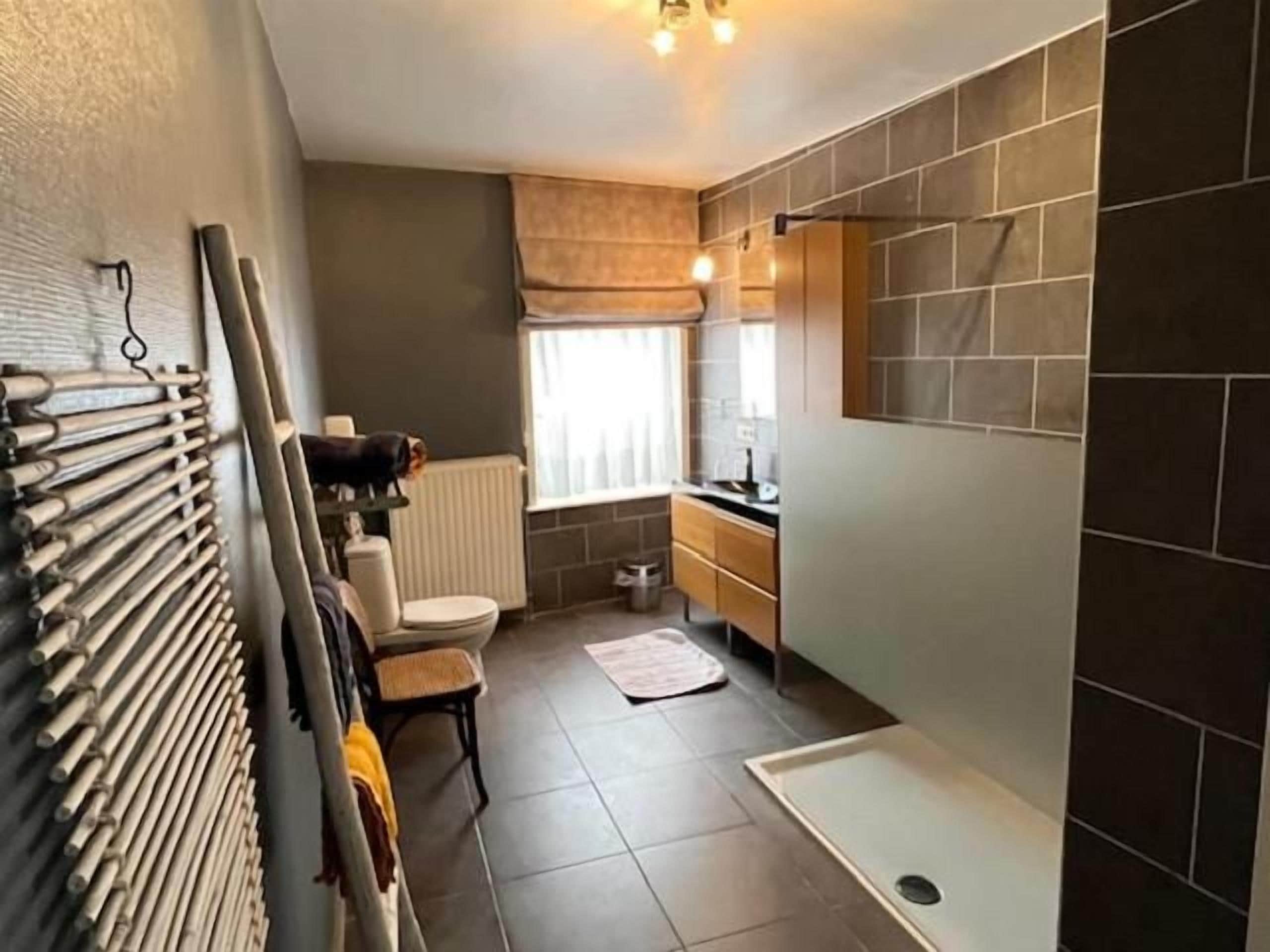 A compact bathroom with a shower, toilet, and sink.