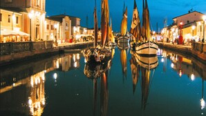 Un canal bordé de bateaux et d’immeubles.