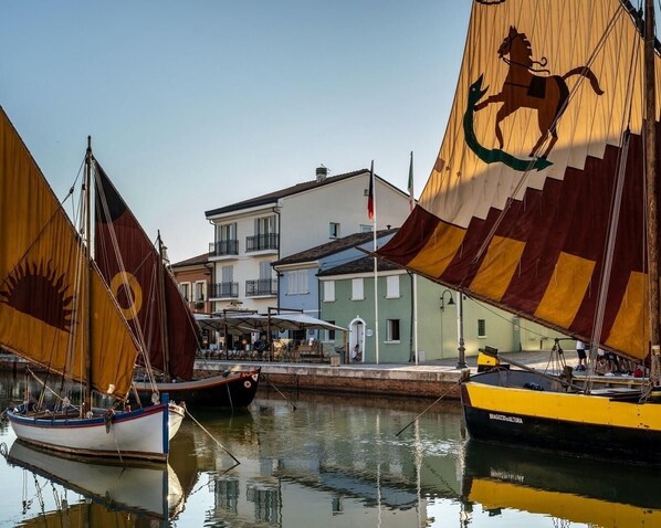 A waterfront scene with boats and buildings. - CasaDodici (Cesenatico)