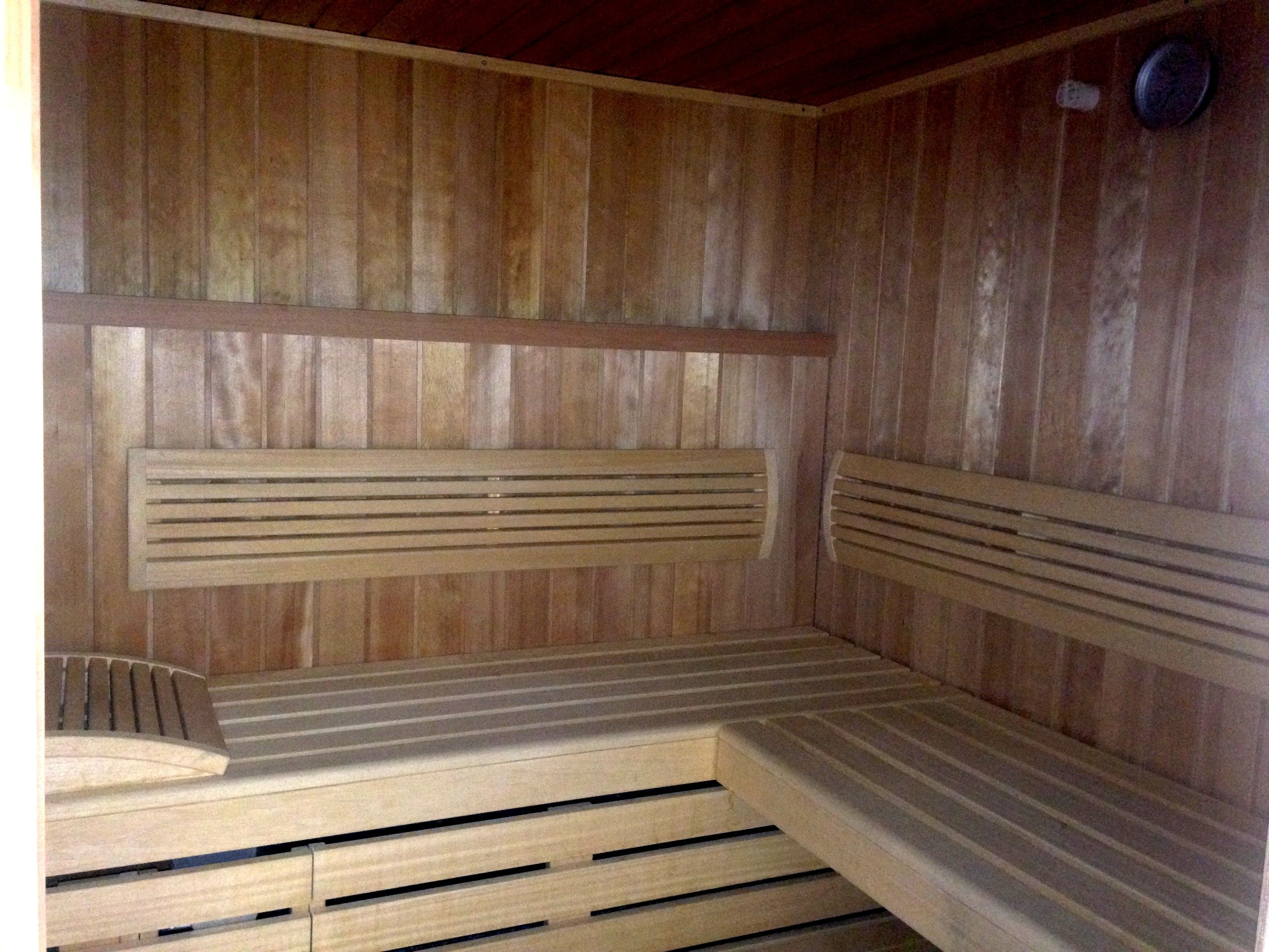A wooden sauna with benches and slatted backrests.