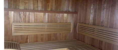 A wooden sauna with benches and slatted backrests.