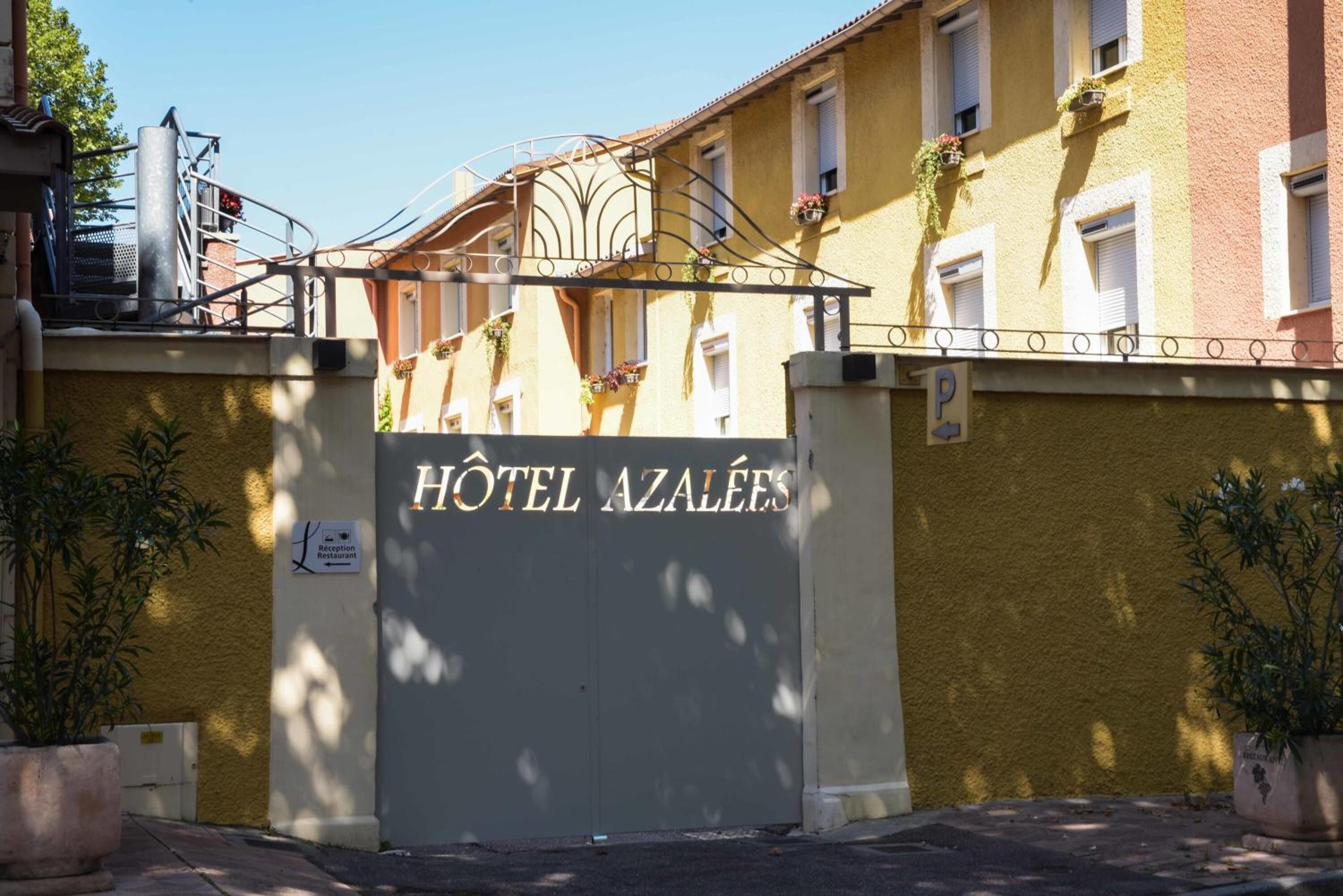 A hotel entrance with a sign reading "HOTEL AZALEES".