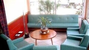 A seating area with a sofa and chairs, a small round table, and a potted plant. - Bel'Air (Jausiers)