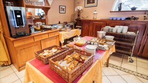 A breakfast buffet setup with bread, pastries, and beverages. - Bel'Air (Jausiers)