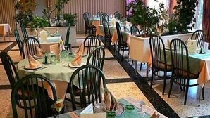 A restaurant with multiple tables set for dining, each with chairs and table settings.