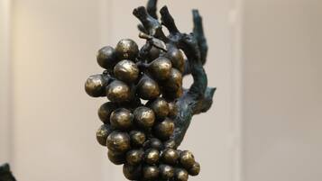 A close-up of a bronze grape cluster sculpture.