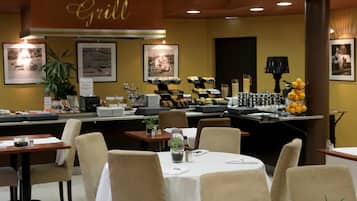 A restaurant with a buffet setup, including various food items and a grill sign on the wall.