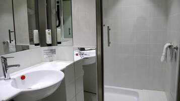 Un bagno con lavandino, specchio e zona doccia.