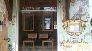 A doorway with a sign indicating a restaurant, framed pictures on the wall, and a mural with a lamp. - Remotel (Knutange)