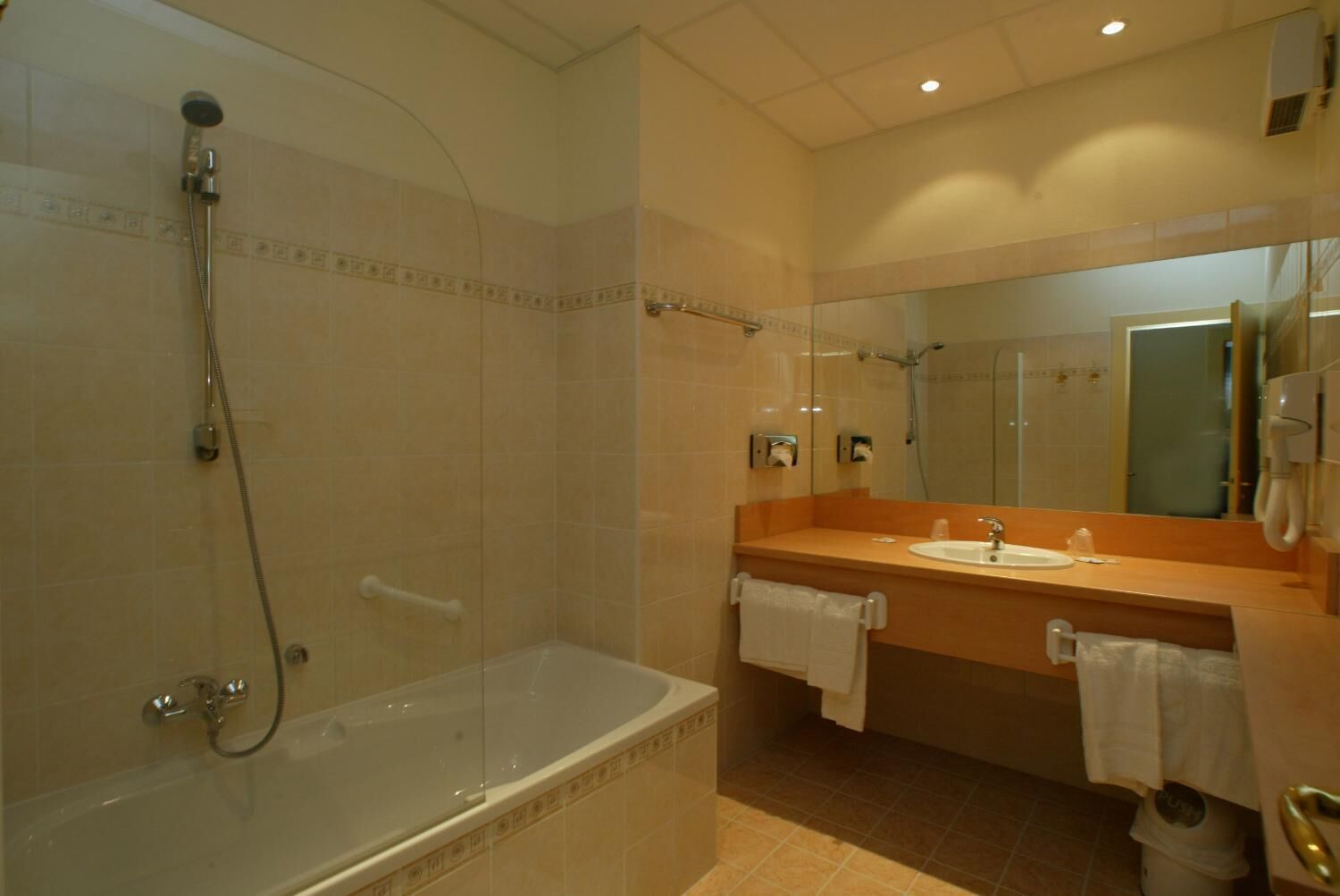 A modern bathroom with a glass-enclosed shower, a standalone bathtub, and a vanity with a mirror and sink.