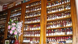 A bar with wooden shelves stocked with various liquor bottles. - Remotel (Knutange)