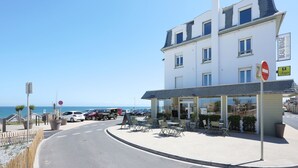 A hotel with outdoor seating, a view of the sea, and a no entry sign. - Le Beau Rivage (Luc-sur-Mer)