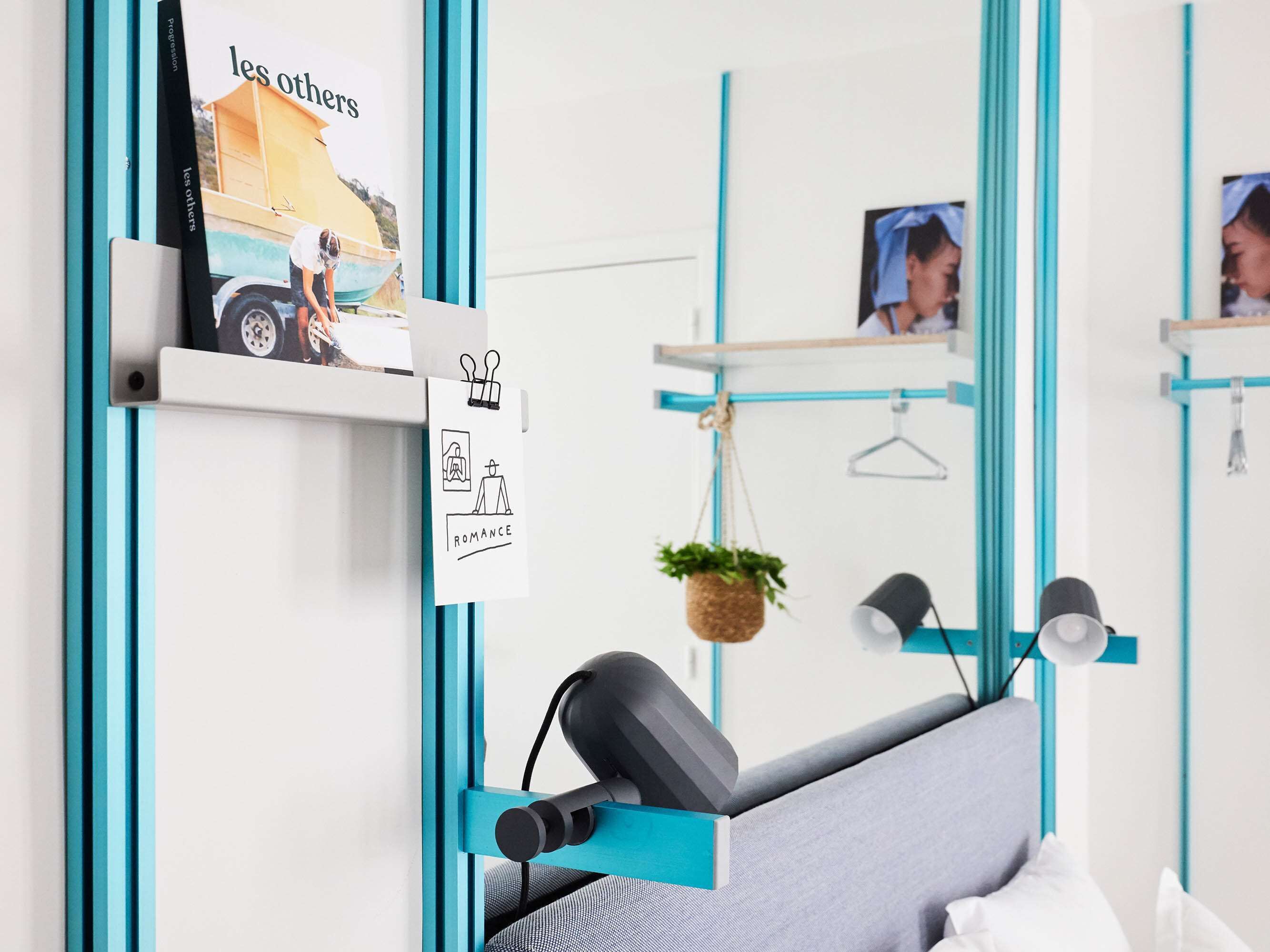 Una habitación moderna con escritorio, planta colgante y espejo.