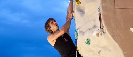 A person climbing a rock wall with various holds.