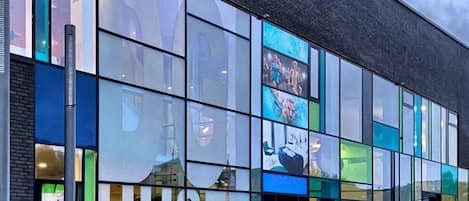 Un edificio moderno con amplios ventanales de vidrio y un cartel que dice "HUSET HERING".