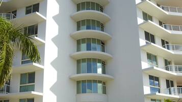 A multi-story hotel with a curved facade, balconies, and a covered entrance area.