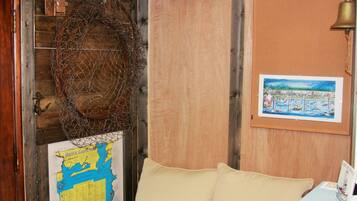 A room with a wooden door, a map on the wall, a bell, and a framed picture.