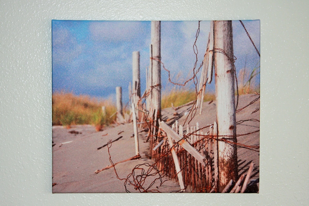 Une scène de plage avec des poteaux en bois et du fil de fer barbelé, évoquant un cadre rustique ou historique.