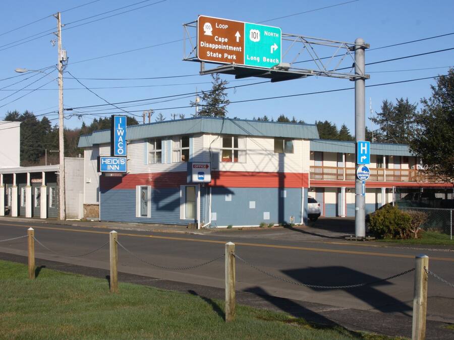 A motel with a sign indicating it is the I.WACO and a nearby highway sign.