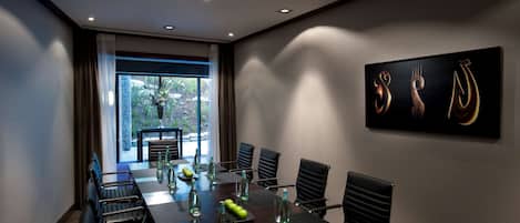 A conference room with a long table, chairs, and a large window.