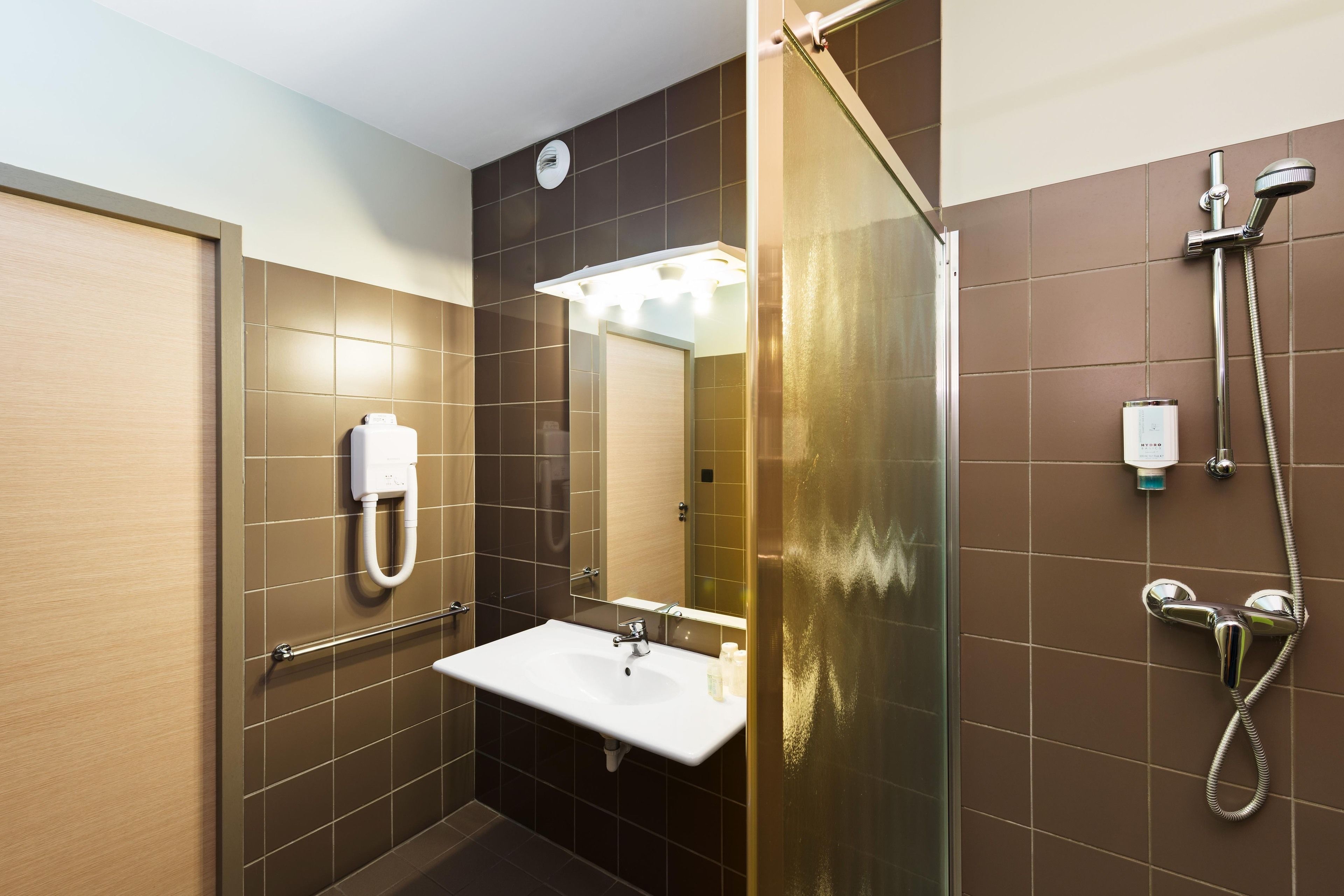 Une salle de bain moderne avec un lavabo, un miroir et une douche.