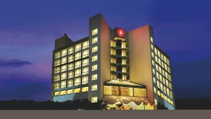 A multi-story hotel with a prominent red logo on the corner, large windows, and a well-lit facade. - Ramada by Wyndham Navi Mumbai (Navi Mumbai)