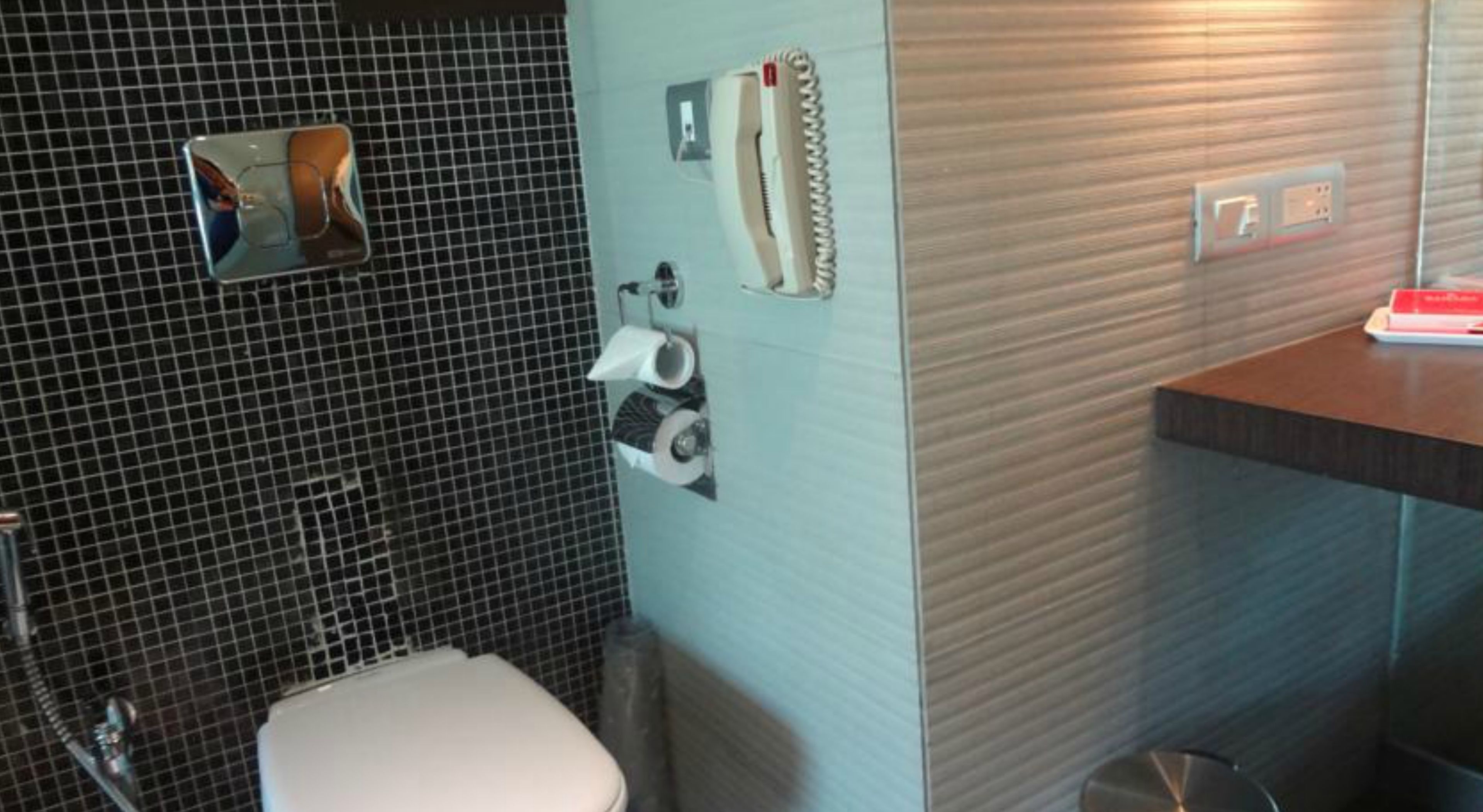 Une salle de bain équipée d’un WC, d’un lavabo, d’un miroir et d’un porte-serviettes.