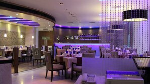 A modern restaurant interior with a bar area, seating arrangements, and ambient lighting. - Ramada by Wyndham Navi Mumbai (Navi Mumbai)