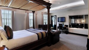 A spacious bedroom with a large bed, a desk, and a television. - Montcalm Brewery, London City (London)
