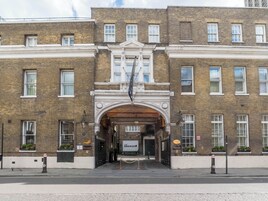 A historic building with a central archway, multiple windows, and a sign indicating it is a brewery.