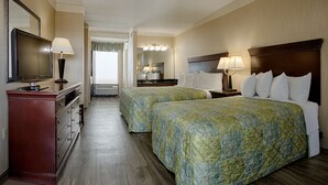A hotel room with two beds, a TV, a dresser, and a bathroom visible through an open door. - The Barefoot Mailman (Ocean City)
