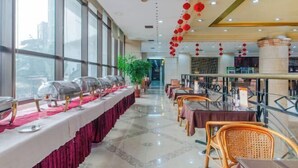 A hotel dining area with a long buffet table, multiple dining tables, and chairs. - Temeisi Hotel (Jieyang)