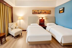 A hotel room with two beds, a desk, a chair, and a lamp. - Temeisi Hotel (Jieyang)
