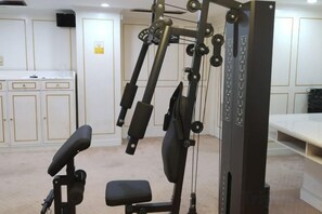 A gym with exercise equipment, a white wall, and a beige carpet. - Temeisi Hotel (Jieyang)