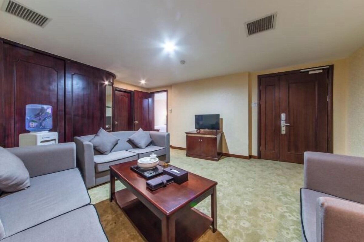 Una sala de estar con sofá, mesa de centro, televisor y armarios de madera.