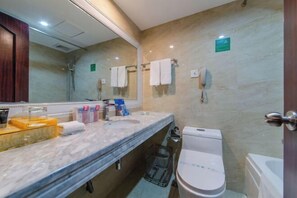 Un baño con tocador de mármol, inodoro, ducha y perchero.