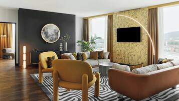Una sala de estar moderna con un sofá, sillones, una mesa de centro y un amplio ventanal con cortinas.