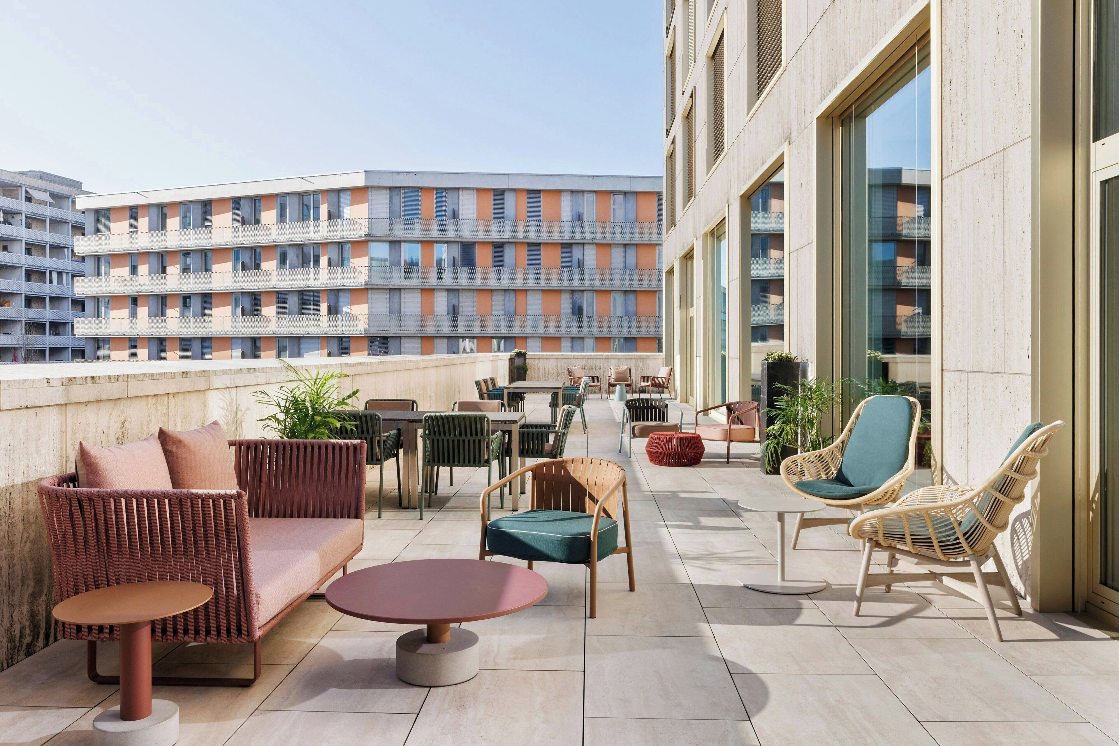 Eine Dachterrasse mit Sitzgelegenheiten im Freien, darunter eine Couch, Stühle und ein Tisch.