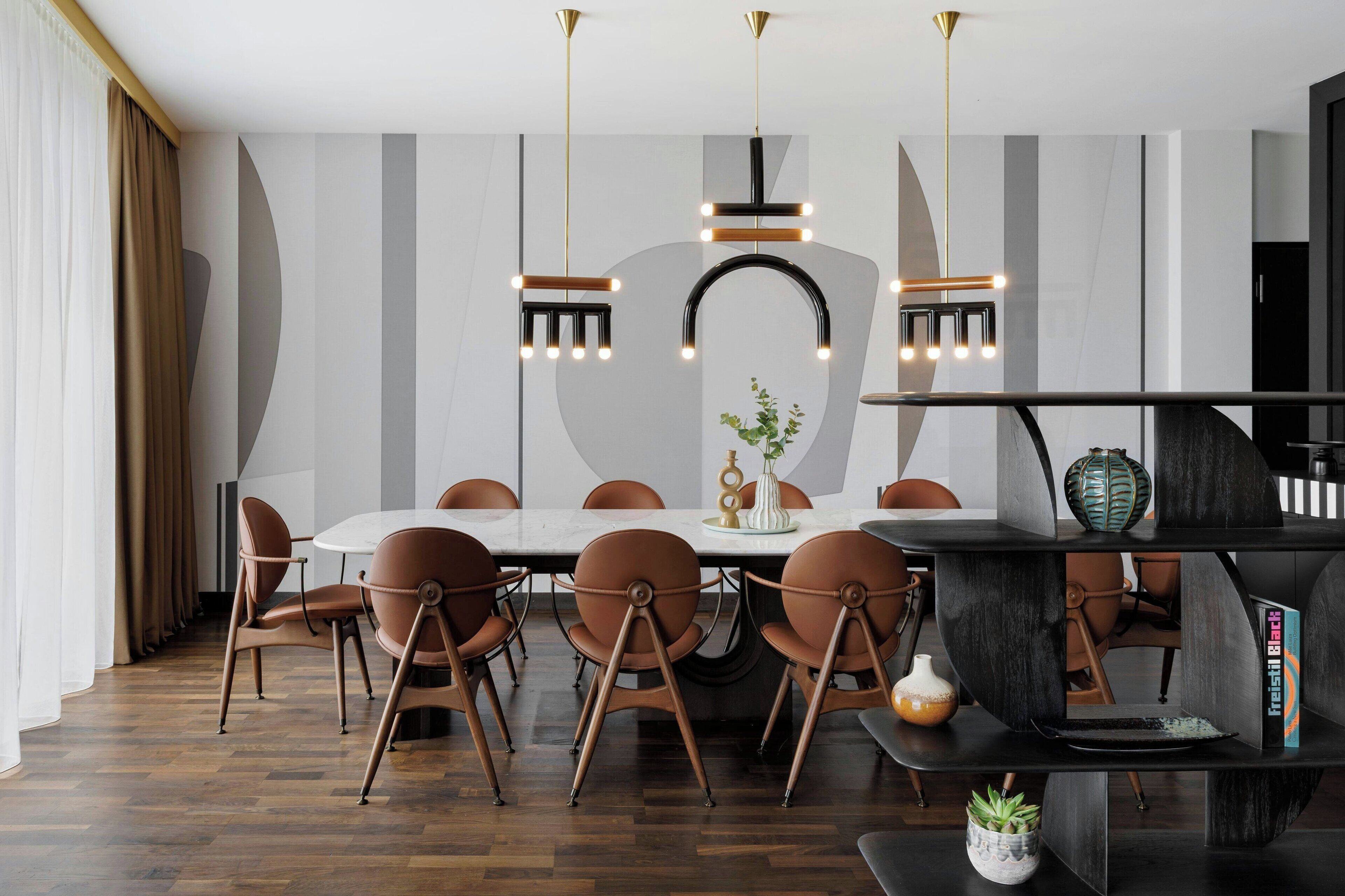 Un espace repas moderne avec une table ronde, des chaises marron et des luminaires suspendus.