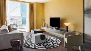 A modern living room with a sofa, a coffee table, a TV, and a lamp.