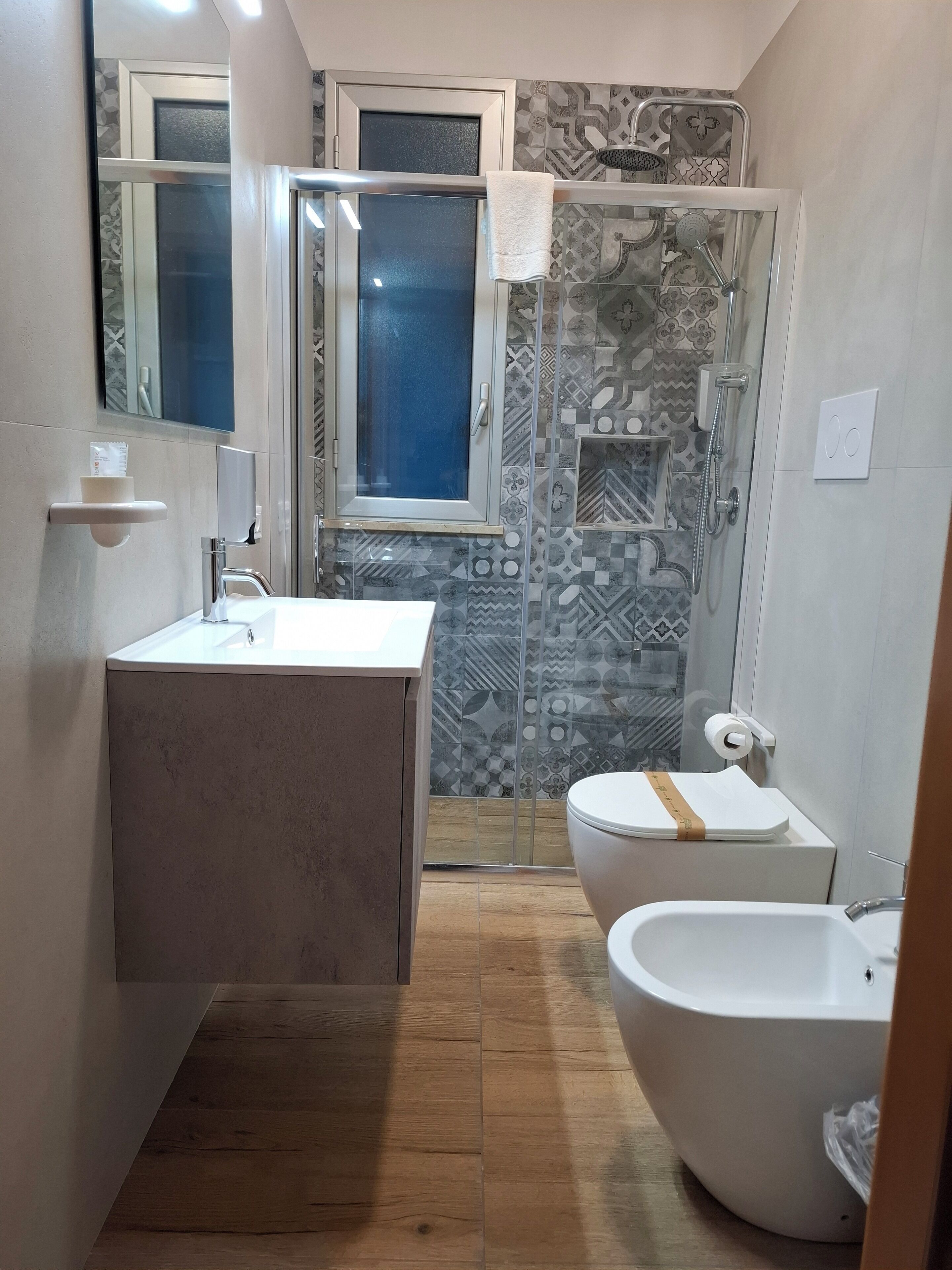 A modern bathroom with a large bathtub, a separate toilet, and a shower area.