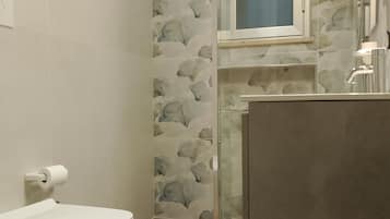 Ein Badezimmer mit Toilette, Dusche und Waschbecken.