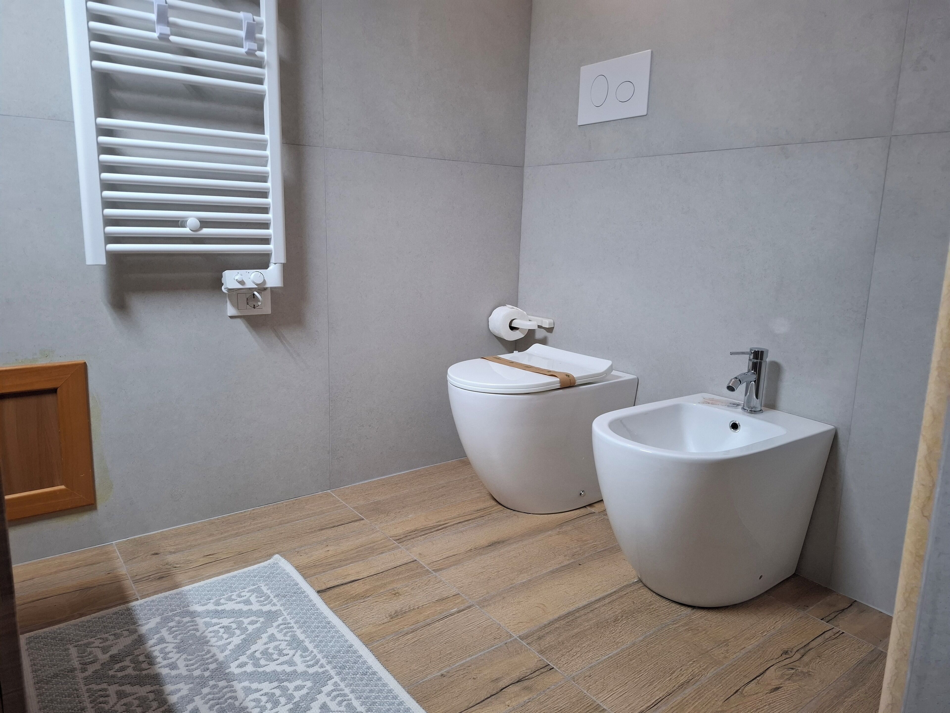 Ein Badezimmer mit Toilette, Bidet und Handtuchhalter.