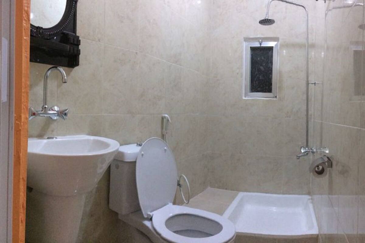 A bathroom with a toilet, bidet, and shower.