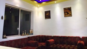 A living room with a large window, a sofa set, and two framed pictures on the wall. - Mussa Spring Hotel (Wadi Musa)