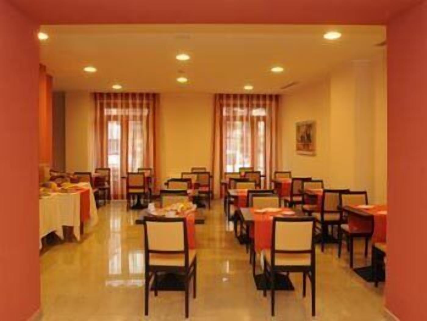 A dining area with tables and chairs, a buffet setup, and a window with curtains.