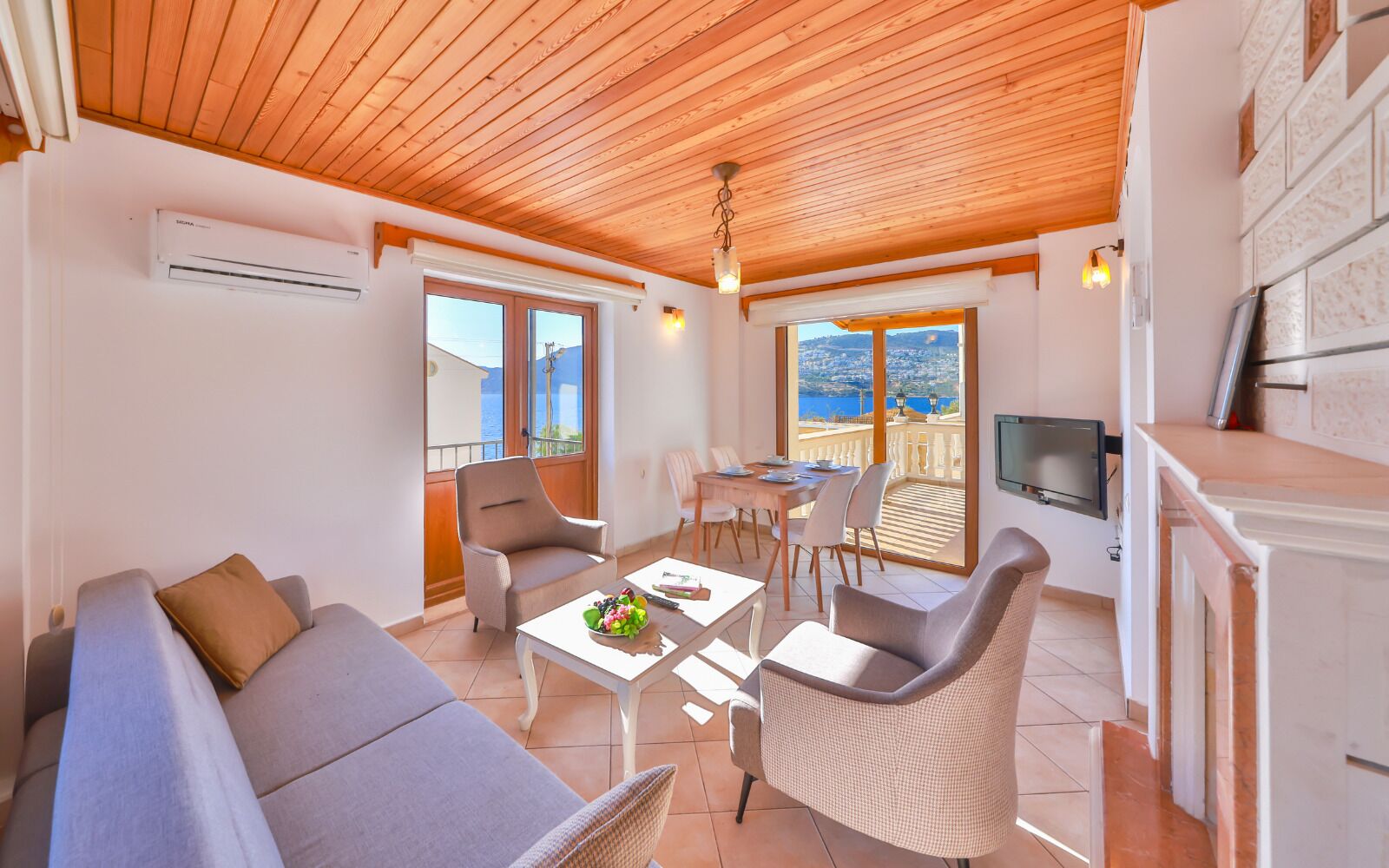 A living room with a sofa, chairs, a dining table, and a TV.