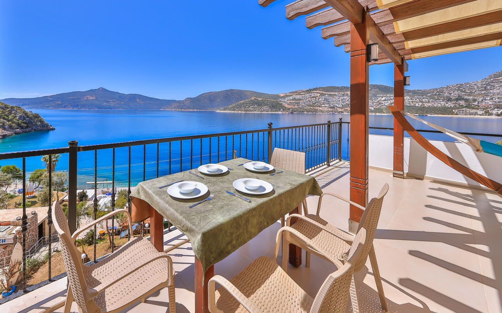 A table set for four with a view of a coastal landscape.