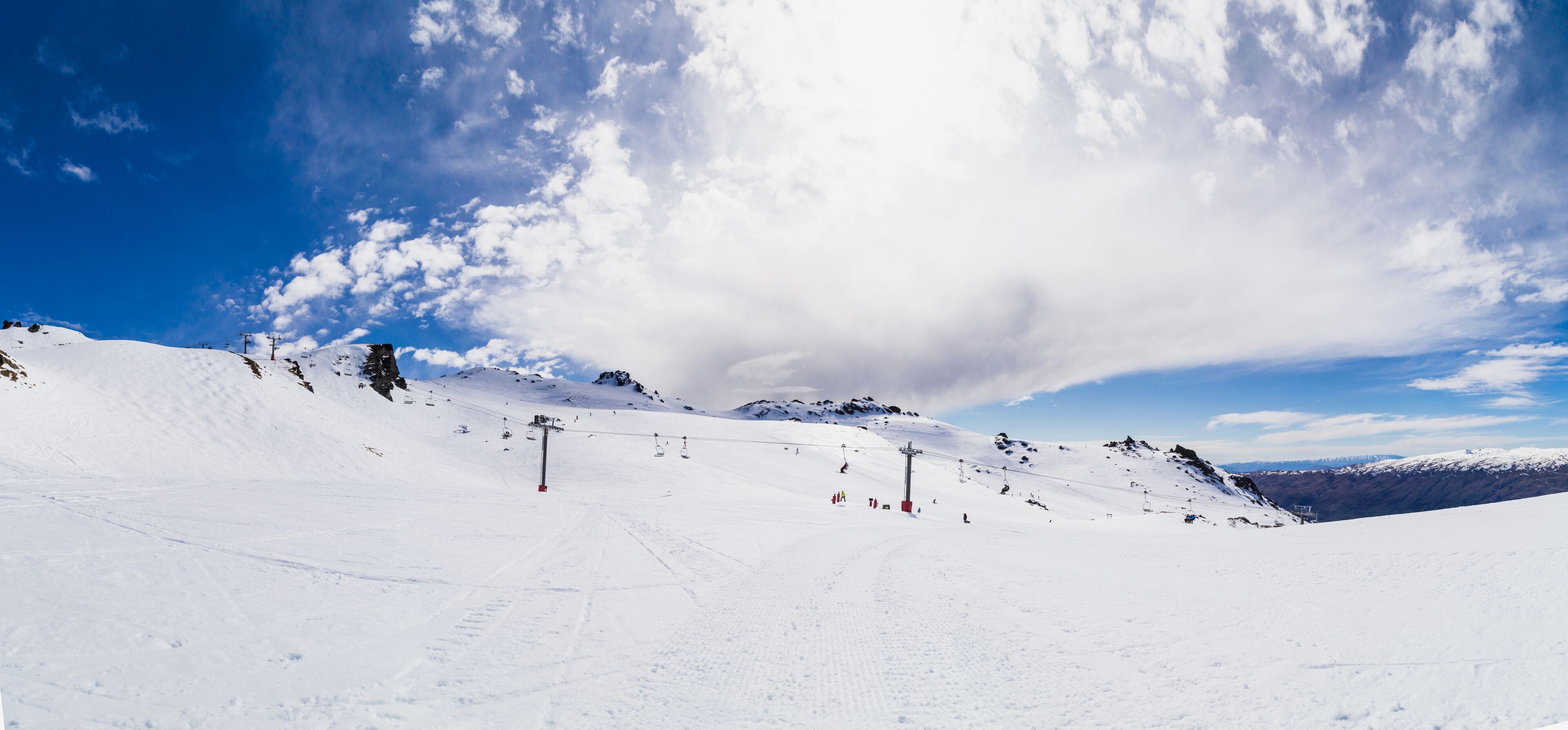 A snowy mountain landscape with ski slopes and a ski lift.